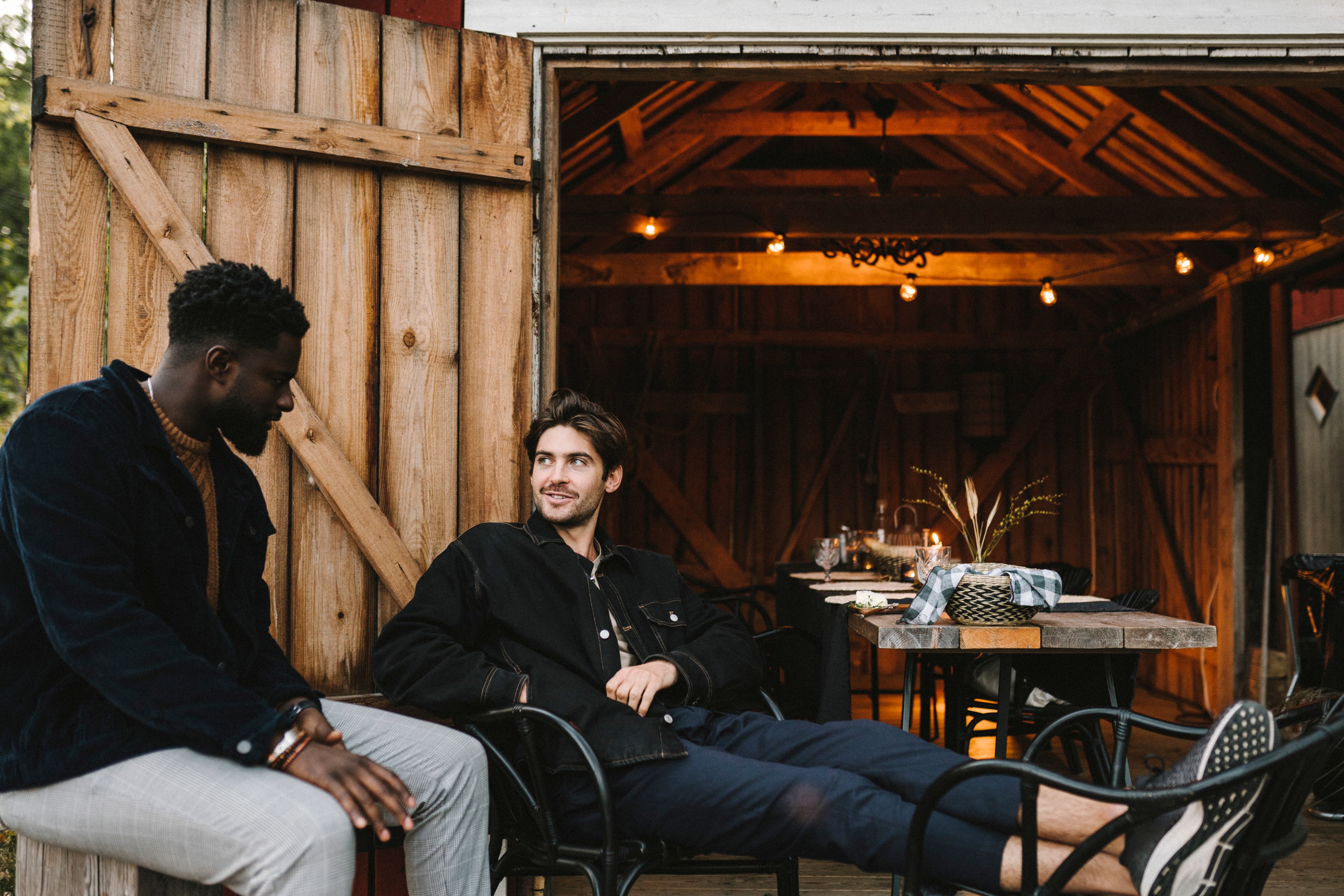 Two young men sitting outside the door of a party.