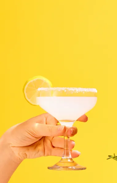 4 hands outreached towards the center, each holding different alcoholic beverages over a yellow background.